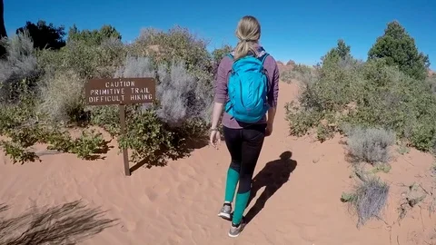 Female hikes down primitive trail in Arches NP Stock Footage 79574793