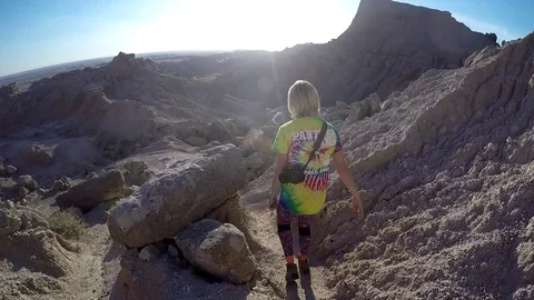 Female Hikes down steep trail in Badlands National Park Stock Footage 81765348
