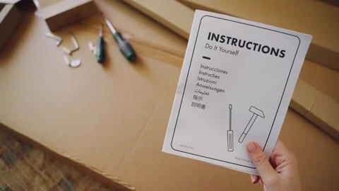 Female holding DIY instructions before assembling furniture Video stock 347030182