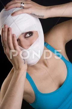 Female holds face first aid gauze wrapped head injury pain Stock Photos