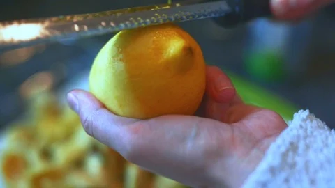 Female home cook zesting a freshly picked organic lemon in the Stock Footage 112962653