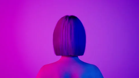 Female hyper-realistic robot or cyborg turn around in studio with neon light Stock Footage 243680533