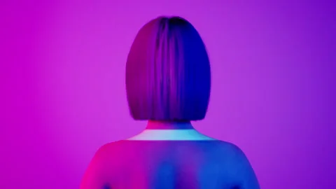 Female hyper-realistic robot or cyborg turn around in studio with neon light Stock Footage 243907432