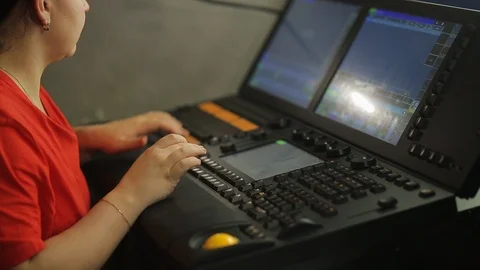 A female illuminator at the remote control programs the stage light for the show Stock Footage 124664761