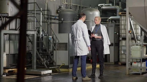 Female inspector talking to chief engineer in factory Stock Footage 127701175