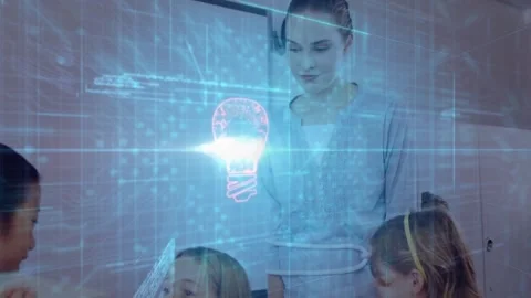 Female instructor guiding students around classroom table, projecting lit bulb Stock Footage 325964950
