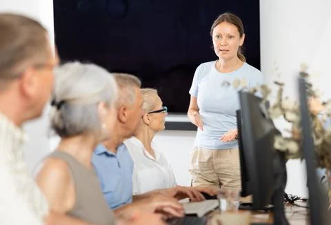 Female instructor leading computer session for older adults Stock Photos