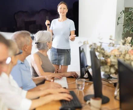Female instructor leading computer session for older adults Stock Photos