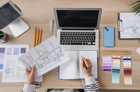 Female interior designer drawing plan at table in studio, top view Stock Photos