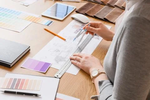 Female interior designer drawing plan at table in office Stock Photos