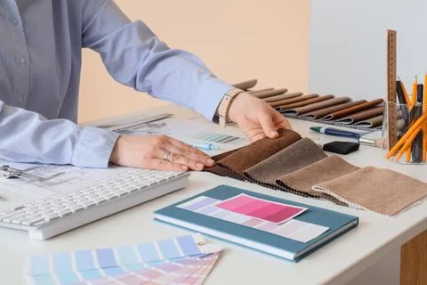 Female interior designer with fabric samples working at table in office Stock Photos