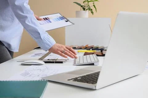 Female interior designer working with computer at table in office Stock Photos