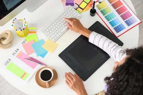 Female interior designer working with computer at table in office, top view Stock Photos