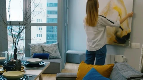 Female Interior Designers Decorating Wall with Abstract Painting Vidéo 101362661