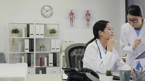 Female intern asking advice from asian doctor Stock Footage 104900447