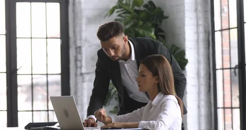 Female intern learning computer software talking to mentor in office Stock Footage 122305799