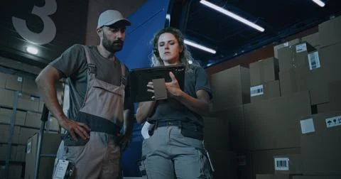 Female Inventory Specialist Using Tablet Computer, Loader Checking Cardboard 写真素材