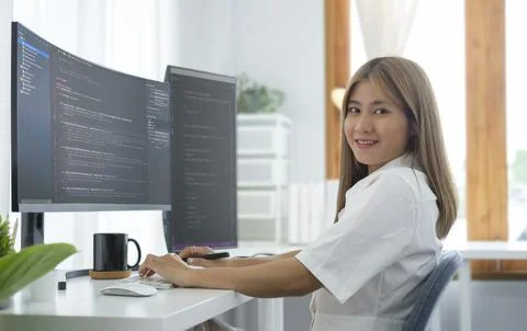 Female IT developer sitting at her workplace with programming code on compu.. Foto stock