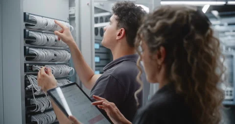 Female IT Engineer Supervising Ethernet Patching with Live Server Telemetry Stock Footage 344964969