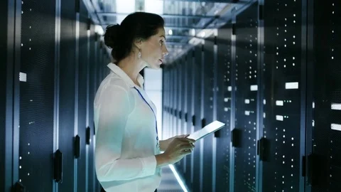 Female IT Engineer Works on Tablet Computer in Data Center Full of Rows of Rack  Video stock 73667342