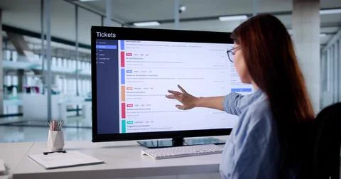 Female IT Specialist Resolving Computer Issues Remotely Using Helpdesk System Stockfoto's