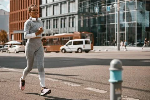 Female jogger having regular training outdoors on a sunny day during pandemic Stock Photos