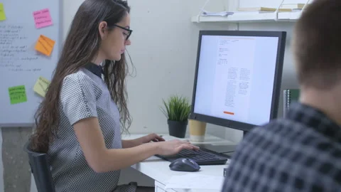Female journalist in front of large computer monitor, writing news report Stock Footage 142241999