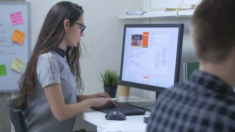 Female journalist in front of large computer monitor, writing news report Stock Footage 142242948