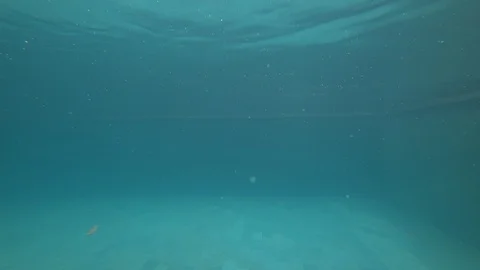 Female jumping into pool creating air bubbles. Underwater camera  Stock Footage