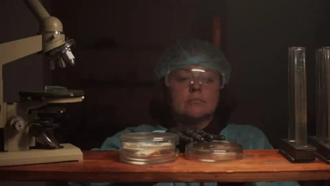 A female laboratory assistant puts the object of study on a storage shelf next t Stock Footage 233031166
