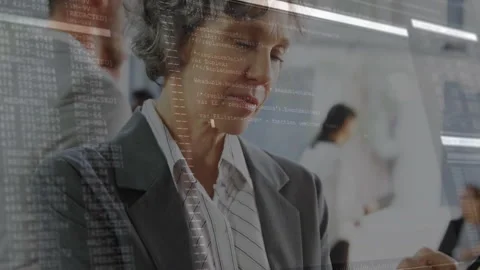 Female leader tapping tablet screen and activating animated code overlays for Stock Footage 312415606