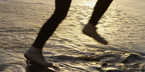 Female Leaps in Ocean at Sunset on Beach Stock Footage 90433448