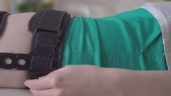 Female wearing knee orthosis or knee support brace after surgery