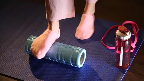 Female leg is rolling the foam roller to massage leg muscles Stock Footage 130454490