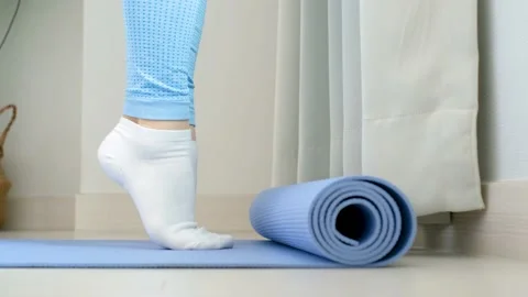 Female legs doing exercises lifting on toes close-up on blue background, side Vidéo 234581199