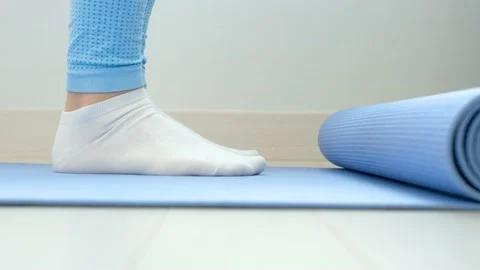 Female legs doing exercises lifting on toes close-up on blue background, side Stock Footage 234863940