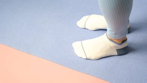 Female legs doing exercises lifting on toes close-up on pink background. Stock Footage 237146656