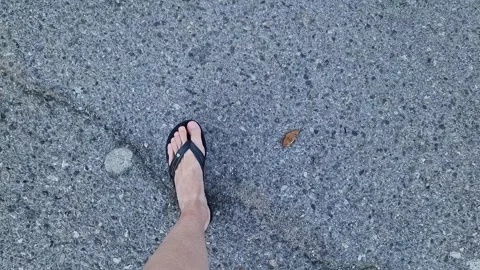Female legs in flip flops walking down the street, first person view Stock Footage 295889187