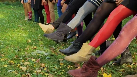 Female legs on grass. Tights of different colors on girls' legs Stock Footage 78383411