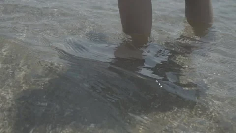 Female legs move on seafront Splash of water Holiday on beach . Stock Footage 133563458