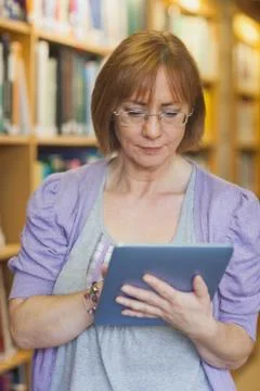 Female librarian using concentrated her tablet Stock Photos