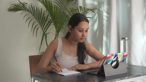 Female listening to an online course,making notes,Concept of online learning. 動画素材 148499010