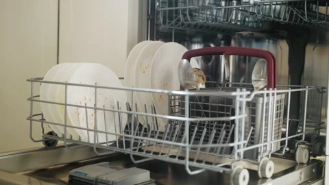 Female loading dirty plates into dishwasher machine. Housewife uses modern Video stock 196215992