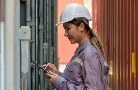 Female logistics engineer in hard hat using digital tablet Stock Photos