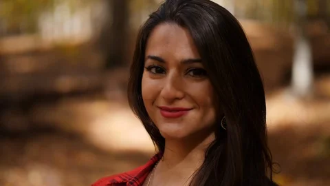 Female looking directly at the camera. She is in a colorful forest Video stock 103435041