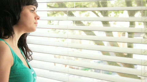 Female looking out of window Stock Footage 786429