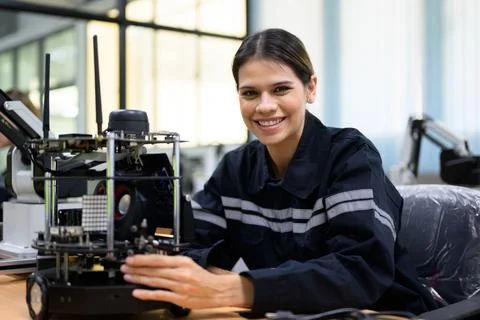 Female maintenance engineer checking and repairing automatic robotic machine 写真素材