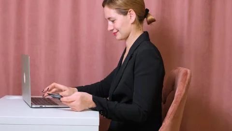 Female make a purchase on the Internet using a laptop, payment by card, close-up Stock Photos