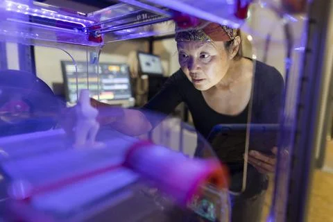 Female maker using 3D printer in workshop Foto stock