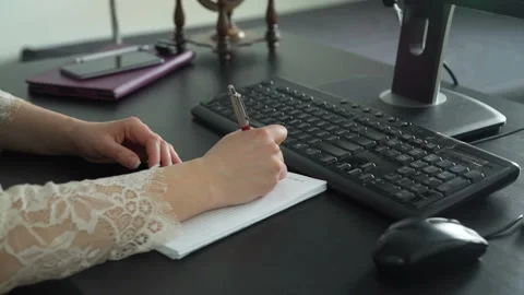 Female Making Notes in Notebook and Typing on PC 動画素材 105852112